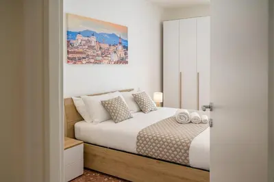 a bedroom with a bed and a painting on the wall at Luxury Domus- Metro Malatesta in Rome