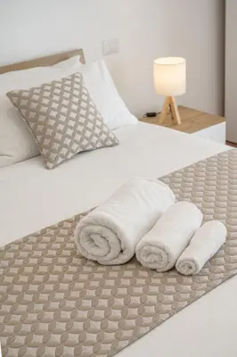 a bed with two rolled towels on it at Luxury Domus- Metro Malatesta in Rome