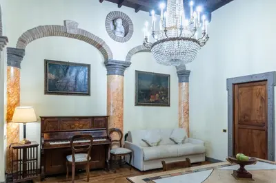 a living room with a chandelier and a couch and a piano at Roman Charme Spagna in Rome