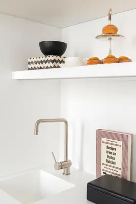 a white kitchen with a sink and a counter top at Crossing Condotti in Rome