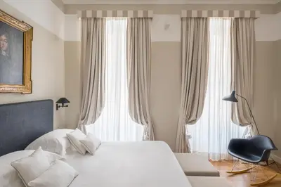 a bedroom with a bed and two large windows at Crossing Condotti in Rome