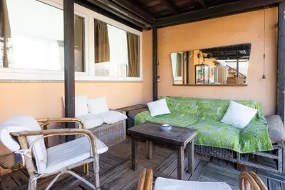 a screened in porch with a couch and a table at Borgo Vittorio Terrace by Rental in Rome in Rome