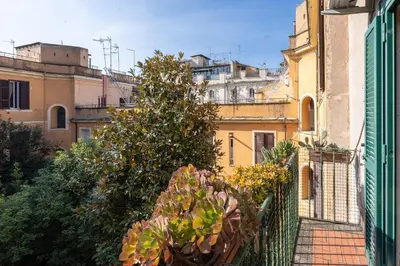 a balcony with plants on a fence and buildings at Borgo Vittorio Terrace by Rental in Rome in Rome