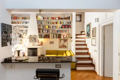 a living room with a yellow couch and a staircase at Borgo Vittorio Terrace by Rental in Rome in Rome