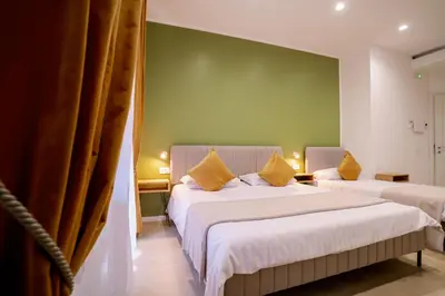 two beds in a room with a green wall at 4 Seasons Roma Trastevere in Rome