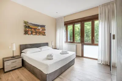 a bedroom with a large bed and a large window at ROMAN DREAM lll in Rome