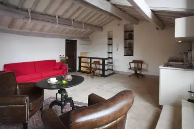 a living room with a red couch and a table at Laurina F1 Studio with Panoramic Terrace - LOCAPPART in Rome