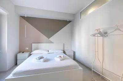 a bedroom with a white bed with two towels at Vatican Suites in Rome