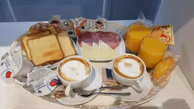 a plate of breakfast foods and drinks on a table at Imperial Relais in Rome