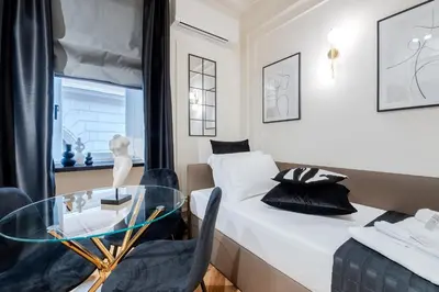 a room with a bed and a glass table and chairs at Acque Romane Maison Trevi Crociferi in Rome