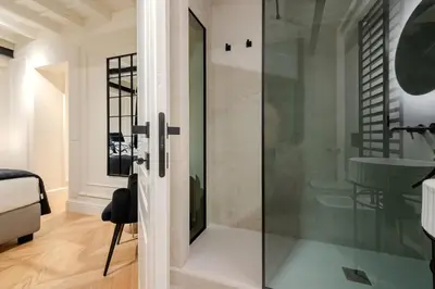 a glass shower door in a bathroom with a sink at Acque Romane Maison Trevi Crociferi in Rome