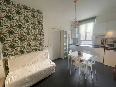 a living room with a white couch and a table at Appartamento Boho a San Lorenzo ,quartiere della street art in Rome