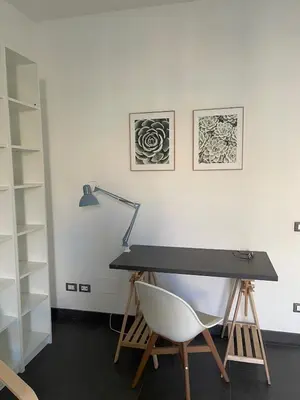 a desk with a white chair and a lamp at Appartamento Boho a San Lorenzo ,quartiere della street art in Rome
