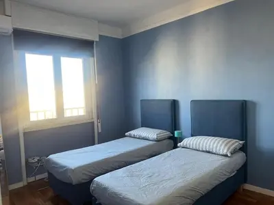 two beds in a room with blue walls at Belvedere home in Rome