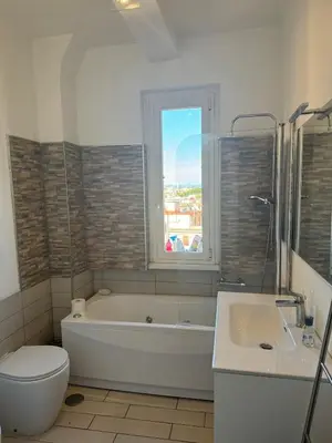 a bathroom with a tub and a toilet and a sink at Belvedere home in Rome