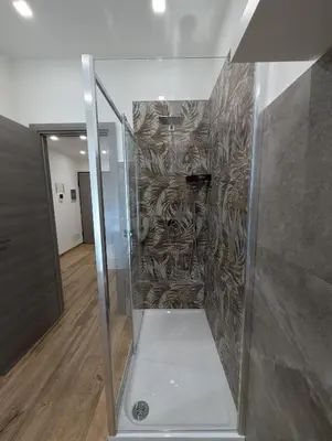 a shower in a room with a wall at Maison Simone Marconi in Rome
