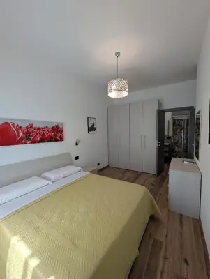 a bedroom with a large bed with a yellow blanket at Maison Maurizio Marconi in Rome