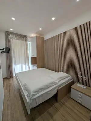 a bedroom with a bed and a wooden wall at Maison Maurizio Marconi in Rome
