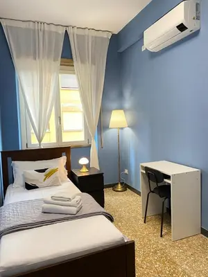 a bedroom with a bed and a desk and a window at Appartamento Roma San Giovanni in Rome
