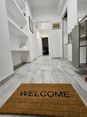 a hallway with a welcome rug on the floor at San Lorenzo Garden Suites in Rome