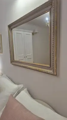 a mirror on a wall above a bed in a room at Sweet Saint Paul in Rome