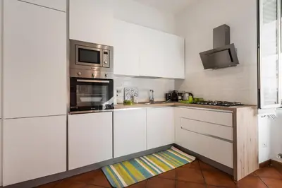 a kitchen with white cabinets and a microwave at Line 8 House in Rome