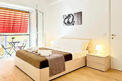 a bedroom with a bed and a balcony with a table at Roma Passion Suite in Rome