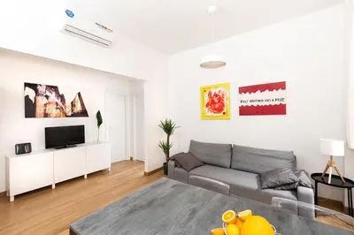 a living room with a couch and a tv at Domus Aurea a stone's throw from the Colosseum in Rome