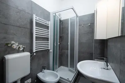 a bathroom with a sink and a toilet and a shower at Domus Aurea a stone's throw from the Colosseum in Rome