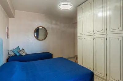 a bedroom with a blue bed and white cabinets at GuestHost - La Rosa di Trastevere in Rome