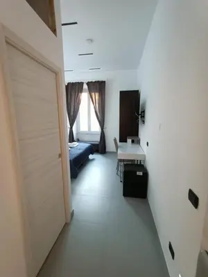 a room with a door and a bed and a table at World Wide Bed Termini in Rome