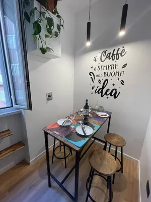 a dining room table with two stools and a sign on the wall at Basilica San Giovanni Appia Antica At a Friends House in Rome