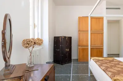 a bedroom with a bed and a dresser and a table at Bright and spacious flat in the hearth of Rome in Rome