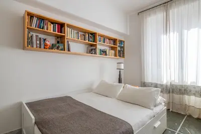 a bedroom with a bed with a book shelf at Bright and spacious flat in the hearth of Rome in Rome