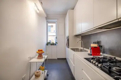 a kitchen with white cabinets and a stove at Bright and spacious flat in the hearth of Rome in Rome