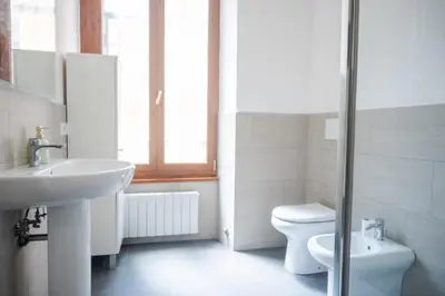 a white bathroom with a sink and a toilet at Suite Vaticano in Rome