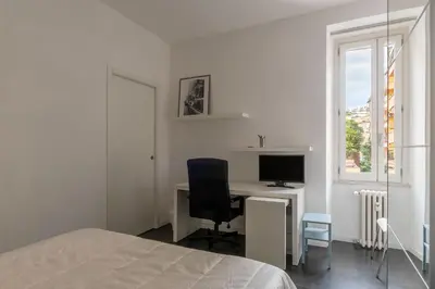 a bedroom with a desk with a computer and a bed at GuestHost - Cozy Apartment near Tiburtina in Rome