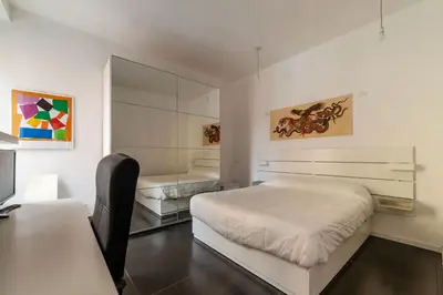a bedroom with a bed and a desk and a mirror at GuestHost - Cozy Apartment near Tiburtina in Rome