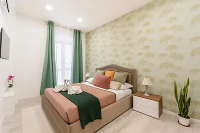 a bedroom with a bed with green curtains at Jhonny's Apartment Near Vatican 3 bedroom's in Rome
