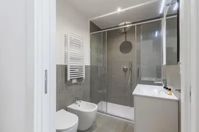 a bathroom with a shower and a toilet and a sink at Hostly-The Montebello Suite-Near Trevi in Rome