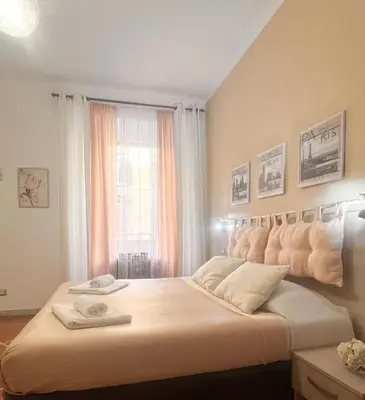 a bedroom with a large white bed with a window at Guest house Aria in Rome