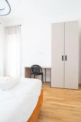 a bedroom with a bed and a chair and a closet at Home d'élite Gregory in Rome