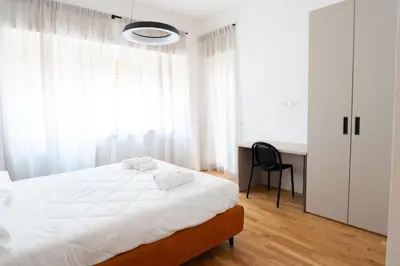 a bedroom with a white bed and a desk at Home d'élite Gregory in Rome