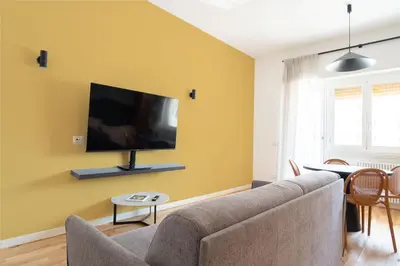 a living room with a couch and a tv on a wall at Home d'élite Gregory in Rome