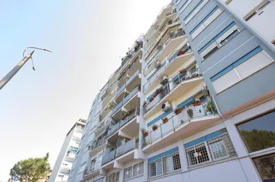 an apartment building with people on the balconies at Green Home Caravaggio in Rome