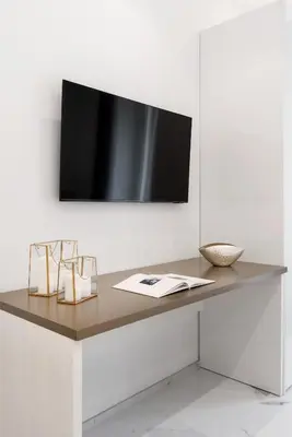 a desk with a television on a white wall at Eternal House Caulonia in Rome