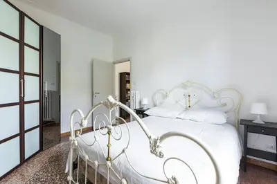 a white bedroom with a white bed with white pillows at La Casa di Edo in Rome