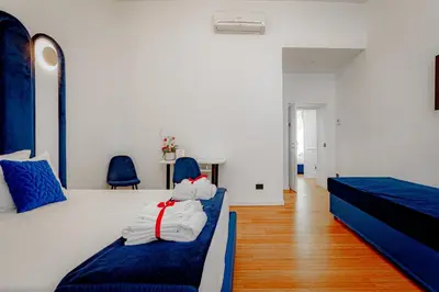 a bedroom with two beds and blue chairs at Historical Center in Rome