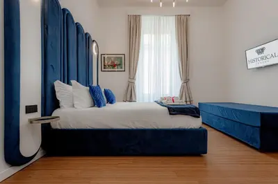 a bedroom with a large bed with a blue headboard at Historical Center in Rome