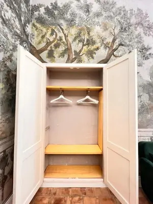 a closet with doors open with a painting on the wall at Historic Fresco Suite Rome Colosseum Boutique Stay in Rome